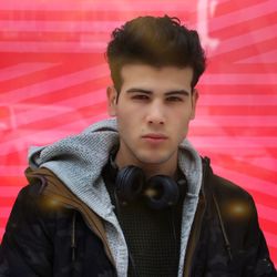 Portrait of young man against red window