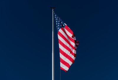 Low angle view of flag against blue sky