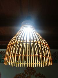 Low angle view of illuminated pendant light hanging on ceiling