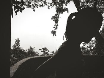 Portrait of silhouette woman standing by tree against sky