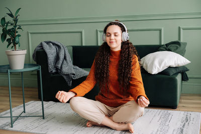 Portrait of young woman sitting on sofa at home