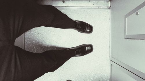 Low section of person standing on tiled floor