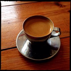 Close-up of coffee cup on wooden table