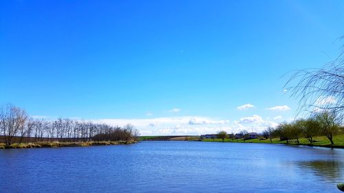 Scenic view of lake against clear blue sky