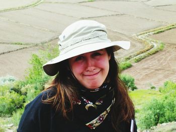 Portrait of smiling woman wearing hat against field