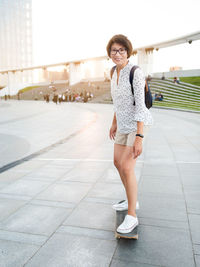 Woman rides skateboard on town square at summer sunset. learning new things in adulthood. 