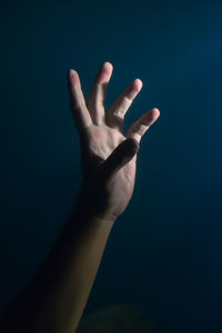 Close-up of hand over black background