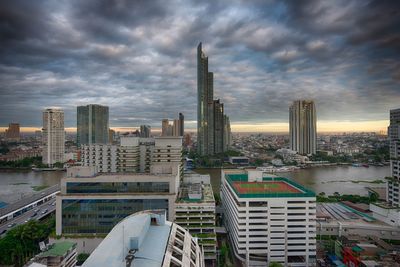 Modern cityscape against cloudy sky