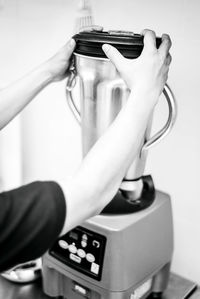 Cropped hands of woman using grinder at home