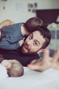 Portrait of father with children on bed at home