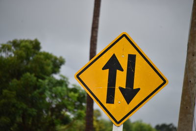 Close-up of road sign against sky