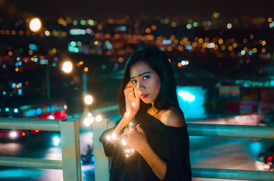 Portrait of smiling woman standing at night