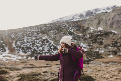 Side view of woman taking selfie while against mountain and sky