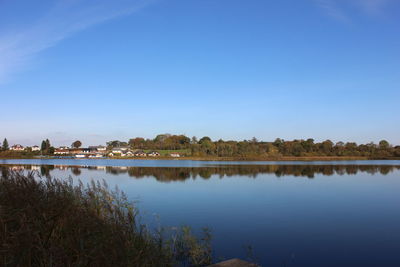 Scenic view of lake against clear blue sky