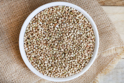 Bowl full of whole buckwheat on rustic surface with copy space