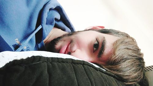 Close-up portrait of young man sleeping on bed