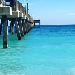 Pier over sea against blue sky