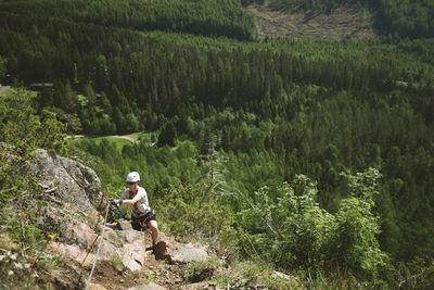 Male mountain climber against green summer landscape