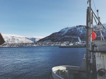 Scenic view of sea by snowcapped mountains against sky