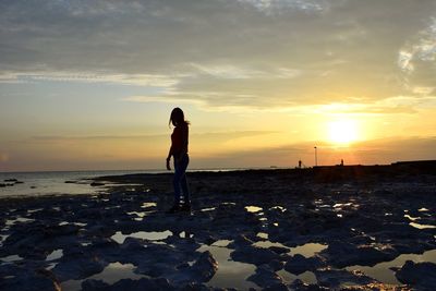 Full length of man standing on beach during sunset