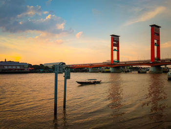 Bridge over river against sky during sunset
