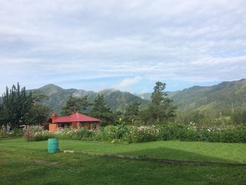 Built structure on field by mountain against sky