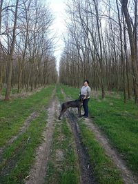 Rear view of woman walking on dirt road