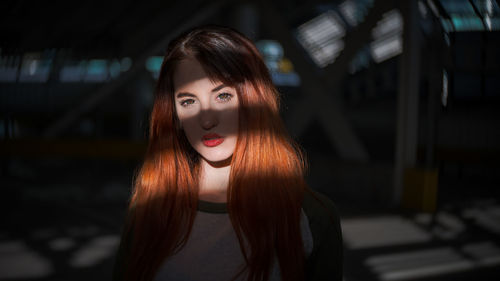 Portrait of young woman in city at night