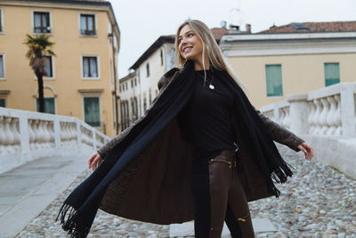 Smiling young woman sitting in city