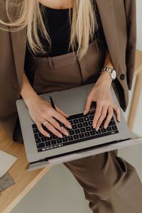 Midsection of woman using laptop on table