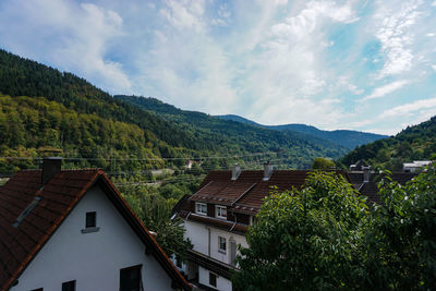 Scenic view of townscape and mountains against sky