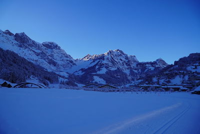 Scenic view of snowcapped mountains against clear blue sky