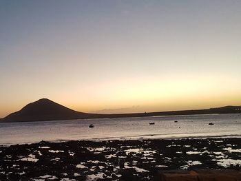 Scenic view of sea against clear sky during sunset