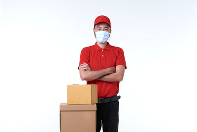 Portrait of young man standing against white background