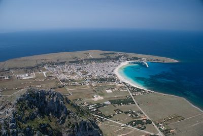 Aerial view of sea and cityscape against sky