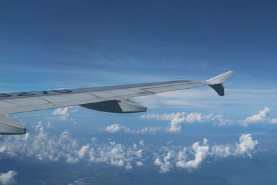 Cropped image of aircraft wing against blue sky