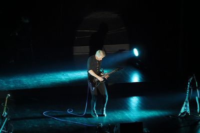 Full length of man standing at illuminated nightclub