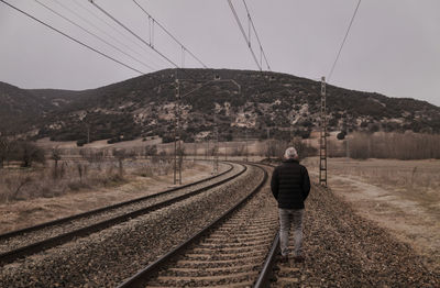 Adult man in warm clothing with railway in countryside. shot in castilla la mancha, spain