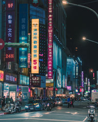 Illuminated city street and buildings at night