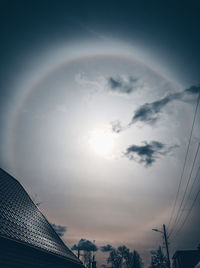 Low angle view of rainbow over building against sky