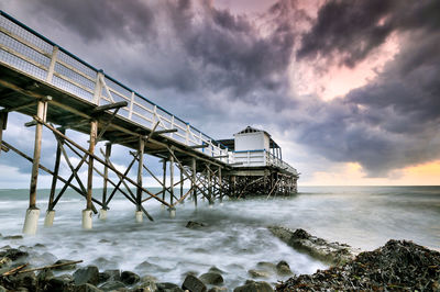 View of bridge over sea against cloudy sky