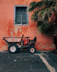 Vintage tractor against building and palm tree