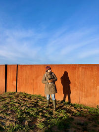 Rear view of women standing against blue sky