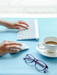 Midsection of woman using laptop on table