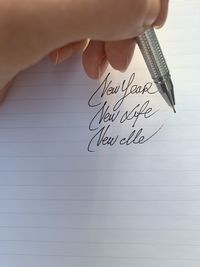 Close-up of hand holding a pen and writting  inspiring notes 