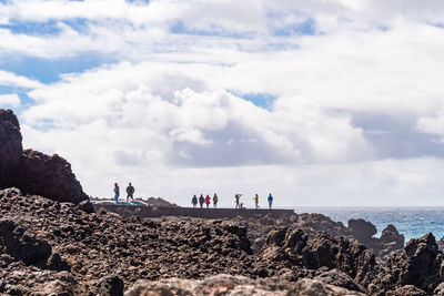 People by sea on rocks