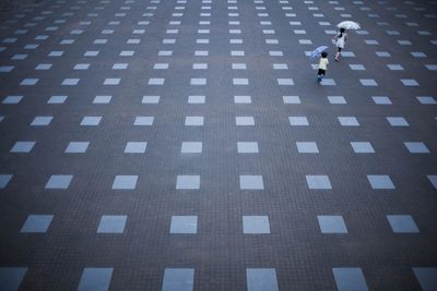 High angle view of children with umbrella running on town square