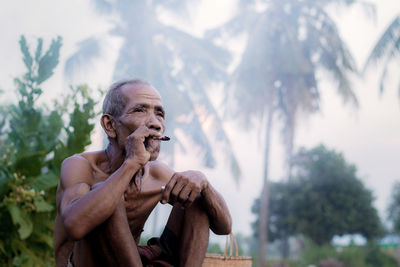 Man looking at camera against trees