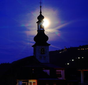 Silhouette of illuminated building against sky at night