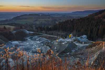 Scenic view of snow covered land against sky during sunset